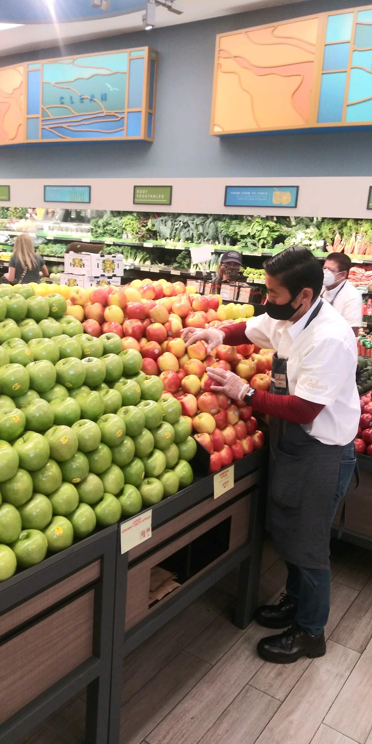 David Sakakura arranging apples in the Gelson’s Westlake store. 