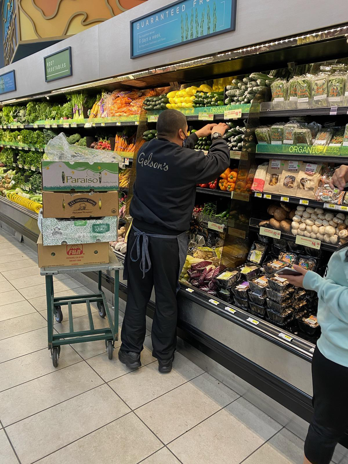 Ed Hilado replenishes a vegetable display in the Gelson’s Silver Lake store. 