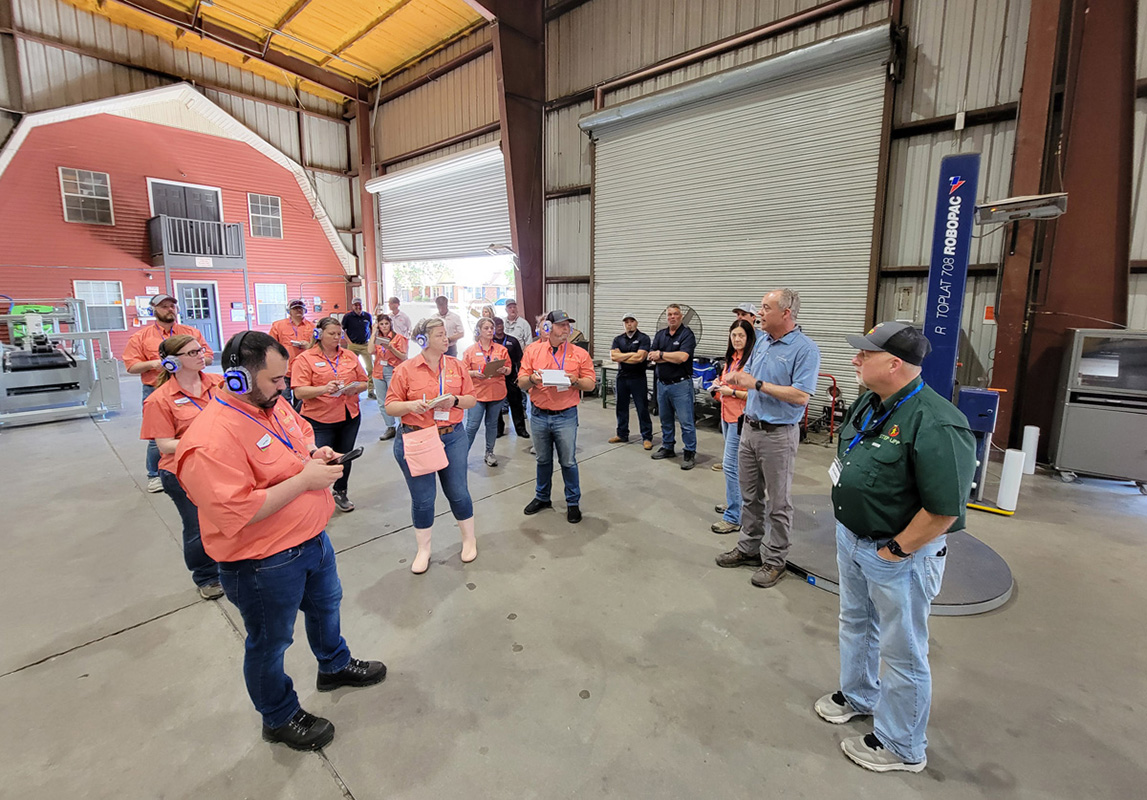 John Shuman (standing in blue shirt), president and CEO of Shuman Farms, greeted the group at the Cobbtown packing facility.